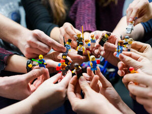 mensen met Lego poppetjes in hun handen